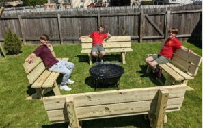 Three boy scout troop members sitting on four new benches made for our meditation trail.